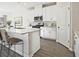 Modern white kitchen featuring an island with bar seating, stainless steel appliances, and hardwood flooring at 422 Radiant Blue Way, Summerville, SC 29486