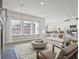 Open-concept living room area with large windows, a fireplace, and modern furnishings at 422 Radiant Blue Way, Summerville, SC 29486