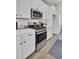 Close-up of kitchen with stainless steel gas range, white cabinets, and hardwood floors at 424 Caledon Ct, Johns Island, SC 29455