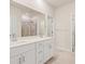 Bright bathroom features double sinks with white cabinetry, a large mirror, and neutral tile flooring at 424 Radiant Blue Way, Summerville, SC 29486