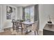 Bright dining room with wooden table, six chairs, modern decor and large window with curtains at 477 Caledon Ct, Johns Island, SC 29455