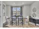 Dining room with wood table, six chairs, modern decor and large window with gray curtains at 477 Caledon Ct, Johns Island, SC 29455