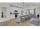 Open-concept kitchen features pendant lights, stainless appliances, white cabinets and a dining area with blue curtains at 477 Caledon Ct, Johns Island, SC 29455
