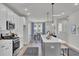Open-concept kitchen features stainless appliances, white cabinets, quartz counters, a dining area, and an island at 477 Caledon Ct, Johns Island, SC 29455
