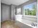 Bathroom featuring a soaking tub with a large window for natural light, plus a glass-enclosed shower, creating a relaxing space at 5289 Mulholland Dr, Summerville, SC 29485