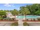 Community pool with lounge chairs, umbrellas, and palm trees at 5289 Mulholland Dr, Summerville, SC 29485