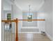 Upstairs hallway featuring white railing with wood trim and overhead natural light at 5289 Mulholland Dr, Summerville, SC 29485