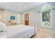 Light-filled bedroom with a comfortable bed, arched window, and a view of the lush outdoors at 62 Eastlake Rd, Mount Pleasant, SC 29464