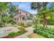 Charming pink two-story home with lush landscaping, palm trees, and a beautifully designed front yard at 62 Eastlake Rd, Mount Pleasant, SC 29464