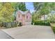 Exterior view of pink home, featuring a multi-car garage and lush landscaping at 62 Eastlake Rd, Mount Pleasant, SC 29464