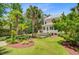 Charming pink two-story home with well-manicured landscaping, lush green lawn and mature palm trees at 62 Eastlake Rd, Mount Pleasant, SC 29464
