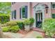 Home's entrance featuring a dark front door, red brick, and lush landscaping at 62 Eastlake Rd, Mount Pleasant, SC 29464