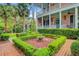 Beautiful two-story home with a charming garden featuring manicured hedges and brick pathways at 62 Eastlake Rd, Mount Pleasant, SC 29464