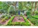 Secluded garden featuring manicured hedges, brick pathways, and a lush, overgrown wall with a hidden door at 62 Eastlake Rd, Mount Pleasant, SC 29464