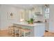 Well lit kitchen island featuring white countertops, straw stools, and light blue cabinets at 62 Eastlake Rd, Mount Pleasant, SC 29464