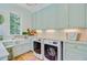 Well-equipped laundry room features a farmhouse sink, modern washer/dryer, and plenty of cabinet space at 62 Eastlake Rd, Mount Pleasant, SC 29464