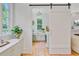 Charming laundry room with updated appliances, built-in cabinets, and a stylish sliding barn door at 62 Eastlake Rd, Mount Pleasant, SC 29464
