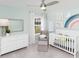Cozy bedroom with ceiling fan, crib and chair, natural light from a window and light mint walls at 724 Meadowbrook Ln, Summerville, SC 29486