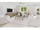 Bright and airy living room with large windows, a mounted TV, and neutral-toned furniture at 724 Meadowbrook Ln, Summerville, SC 29486