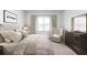 Beautiful main bedroom with a plush, tufted headboard, a cozy chair, and neutral tones at 778 Meadowbrook Ln, Summerville, SC 29486