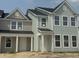 Newly built townhomes boast light green siding, black roof, and white trim, creating a modern farmhouse appeal at 823 Alma Square Dr, Moncks Corner, SC 29461