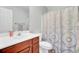 Bright bathroom with wooden vanity and blue shower curtain at 8612 Hickory Creek Ln, North Charleston, SC 29420