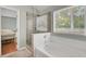 Soaking tub and glass enclosed shower in bathroom with neutral colors at 8612 Hickory Creek Ln, North Charleston, SC 29420