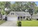 Charming single-story home with a manicured lawn, attached garage, and mature trees at 8612 Hickory Creek Ln, North Charleston, SC 29420