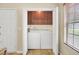 Laundry closet with a front loading washer and dryer and overhead cabinets for storage at 8612 Hickory Creek Ln, North Charleston, SC 29420