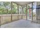 Enclosed porch with concrete flooring and a view of the wooded backyard at 8612 Hickory Creek Ln, North Charleston, SC 29420