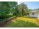 Well-maintained backyard with lush green lawn, rock gardens, mature trees, and privacy hedging at 881 Evans Rd, Charleston, SC 29412