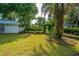Lush backyard with mature trees, rock lined garden, privacy hedges and manicured green lawn at 881 Evans Rd, Charleston, SC 29412