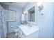 Bright blue bathroom features a white vanity, framed mirror and window with shutters at 881 Evans Rd, Charleston, SC 29412