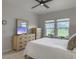 Bright bedroom featuring a ceiling fan, TV, wood dresser and a view of the backyard at 953 Dusk Dr, Summerville, SC 29486