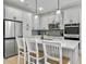 This open kitchen features white cabinets, stainless steel appliances, pendant lighting and a center island at 953 Dusk Dr, Summerville, SC 29486