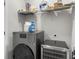 Well-organized laundry area with modern washer, shelving with supplies, and beverage cooler for added convenience at 953 Dusk Dr, Summerville, SC 29486