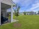A blue rocking chair is featured on this screened porch overlooking the lush lawn at 953 Dusk Dr, Summerville, SC 29486