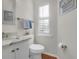 Updated half bath features marble countertop, white cabinets, and wood floors at 1050 Marsh Court Ln, Mount Pleasant, SC 29464
