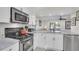 Modern kitchen features white cabinets, marble countertops, and stainless steel appliances overlooking living room at 1050 Marsh Court Ln, Mount Pleasant, SC 29464