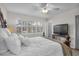 Well lit bedroom with plantation shutters, ceiling fan and flat screen television at 1050 Marsh Court Ln, Mount Pleasant, SC 29464