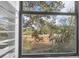 A scenic window view features a lush marsh landscape with mature trees and blue skies beyond, filtered through white blinds at 1050 Marsh Court Ln, Mount Pleasant, SC 29464