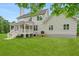 View of the back of the home featuring a white porch and a large vibrant green lawn at 1076 Williams Rd, Charleston, SC 29412