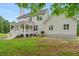 View of the back of the home featuring a white porch and a large green lawn with a few patches of open dirt at 1076 Williams Rd, Charleston, SC 29412