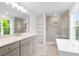 A bright, modern bathroom features a double sink, white cabinetry, marble floors and a glass-enclosed walk-in shower at 1076 Williams Rd, Charleston, SC 29412