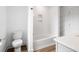 An airy bathroom features a toilet and bathtub, with white tiling, cabinetry, and wood-look floors at 1076 Williams Rd, Charleston, SC 29412