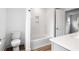 An airy bathroom features a toilet and bathtub, with white tiling, cabinetry, and wood-look floors at 1076 Williams Rd, Charleston, SC 29412