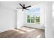 A bright bedroom with a ceiling fan and tall windows showcasing a view of green trees outside at 1076 Williams Rd, Charleston, SC 29412