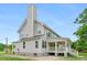 View of the side of the home with a tall chimney and a white porch overlooking the spacious yard at 1076 Williams Rd, Charleston, SC 29412