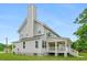View of the side of the home with a tall chimney and a white porch overlooking the spacious yard at 1076 Williams Rd, Charleston, SC 29412
