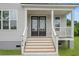 Charming front porch with black double doors and wooden stairs at 1076 Williams Rd, Charleston, SC 29412